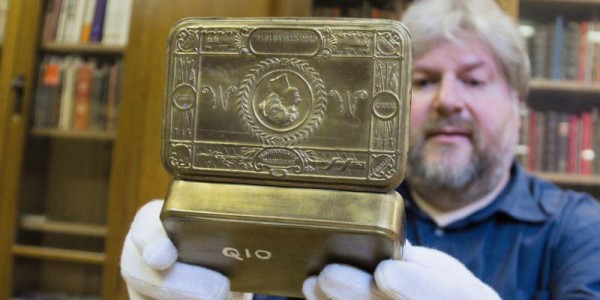 Special collections staff holding a tin