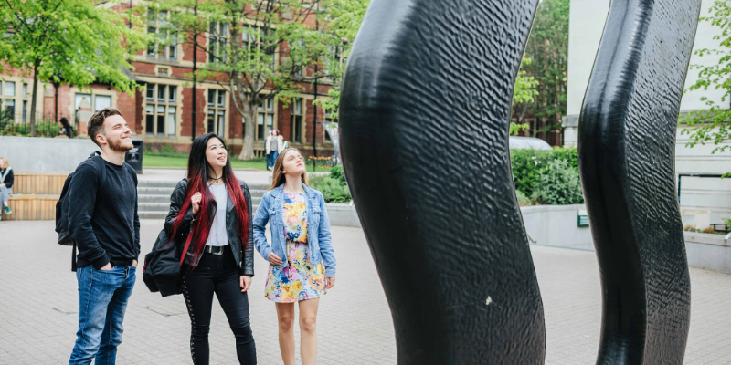 Three people looking at a sculpture