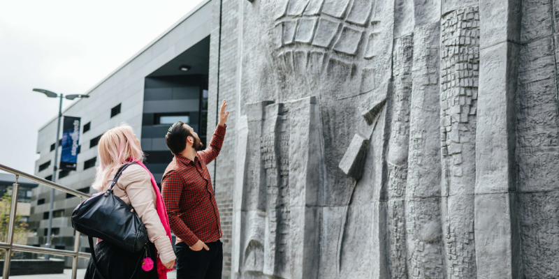 Two people stood admiring a sculpture at the University of Leeds.