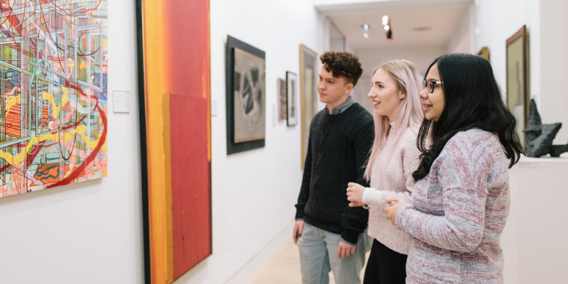 Three students looking at artworks in The Stanley & Audrey Burton Gallery.