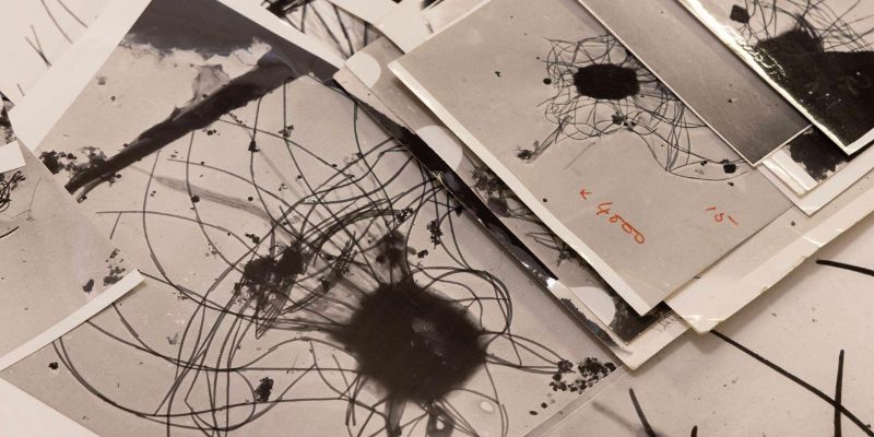 Black and white photographs taken by an electron microscope laid out overlapping on a table.