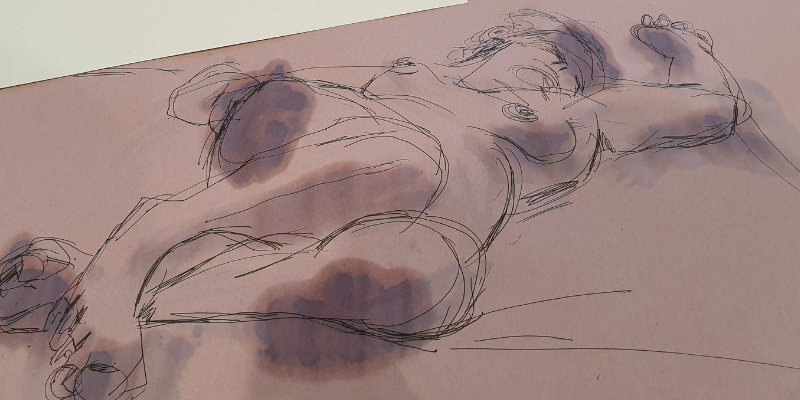 A close crop of a hand holding a pencil and drawing a reclining figure