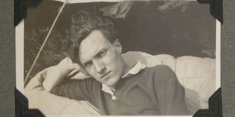 A black and white photo of a man resting his head on one hand.