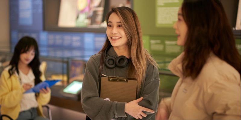 A group of students stood in The Stanley & Audrey Burton Gallery listening to a talk being given by a member of staff about one of the artworks on display.