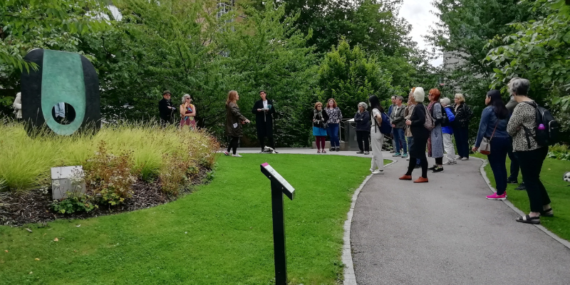 Group of people looking at Barbara Hepworth's sculpture 'Dual Form'