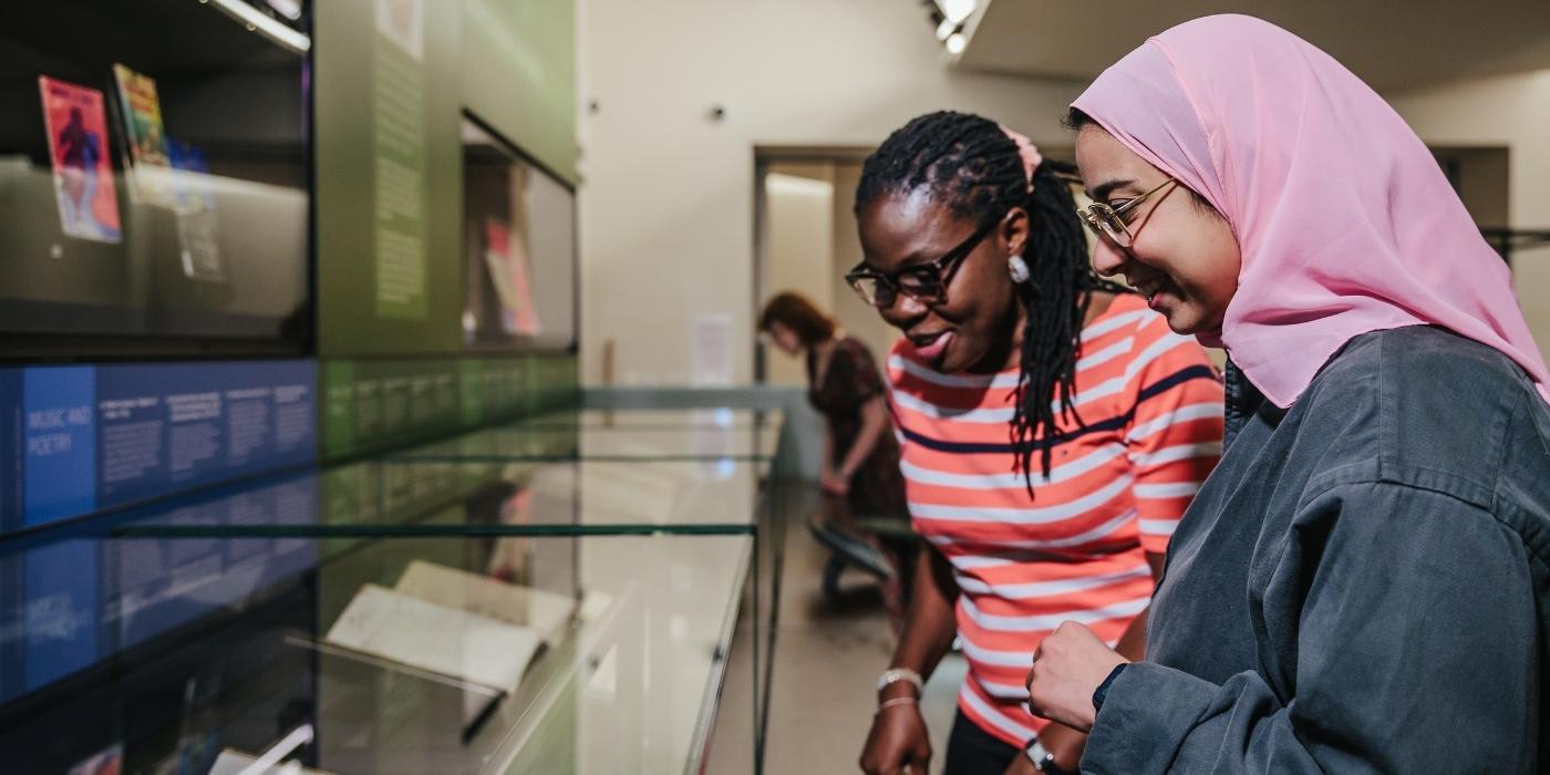 Two visitors looking at the treasures in The Treasures of Brotherton.