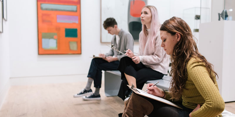 Visitors sketching in the art gallery