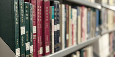 A row of Chinese books on a library shelf.