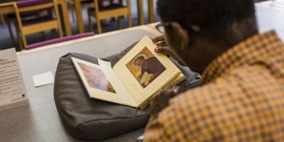 A researcher reads an old book in the Special Collections Research Centre