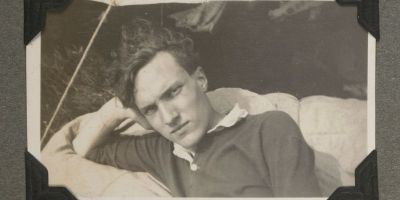 A black and white photo of a man resting his head on one hand.
