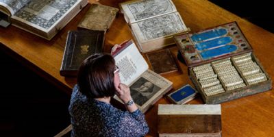 A person looking at a collection on a desk