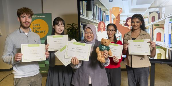 The finalists of the Library Innovation Competition standing in front of competition branded background holding their certificates