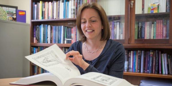 A woman reading a book in an office