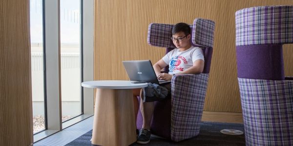 Student working alone on a laptop in the Laidlaw Library