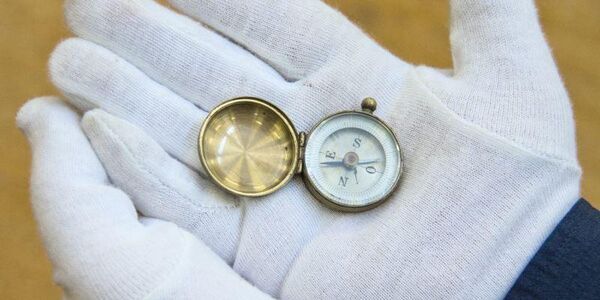 Gloved hands holding a compass