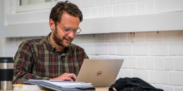 A man studying on his laptop in the West Building.