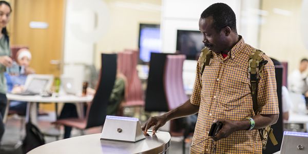 A student scanning their ID card to enter the Laidlaw Library