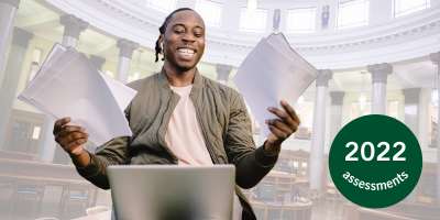 A happy student holds up papers in the Brotherton Library.